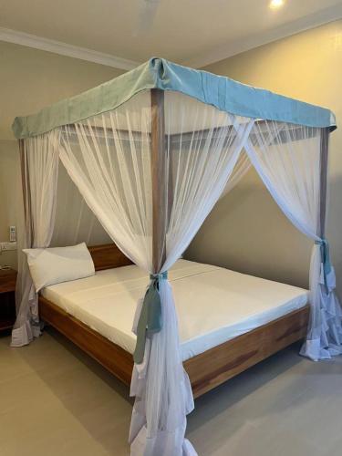 a bedroom with a bed with a canopy at Meat and Mingle Tavern in Paje