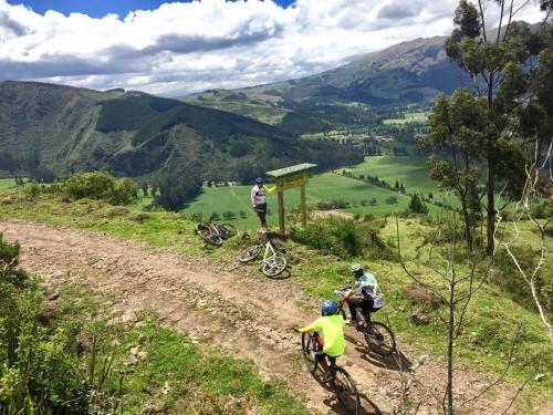 a group of people riding bikes down a dirt road at Santa Rosa de Lima Hostal Zuleta in Zuleta
