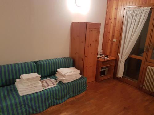 een woonkamer met een groene bank met handdoeken erop bij Appartamento Camporosso in Tarvisio