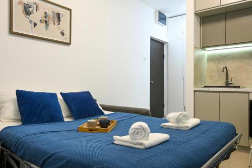 a bedroom with a blue bed with towels on it at Studio Mare Kotor in Dobrota