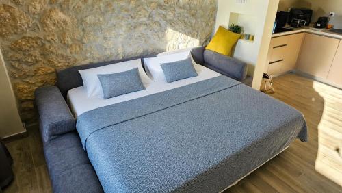 a bedroom with a large bed with blue and yellow pillows at Haven Bay Apartment in Rogotin