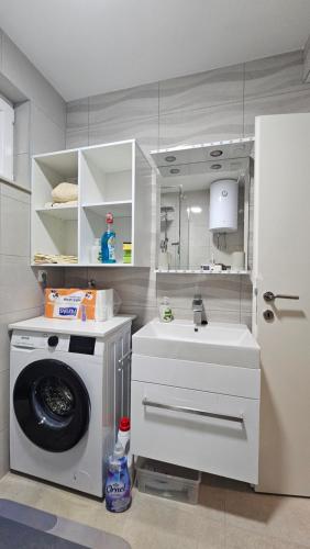 a kitchen with a washing machine and a sink at Haven Bay Apartment in Rogotin