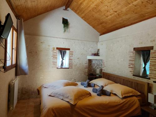 a bedroom with a bed with two teddy bears on it at Lapis Domus in Francueil