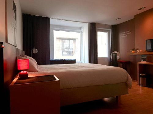 a bedroom with a large bed and a window at Logies Zen aan Zee in Ostend