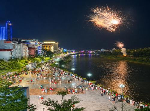 a crowd of people standing on a beach with fireworks at Hồng Thu Hotel Cao Bằng in Cao Bằng
