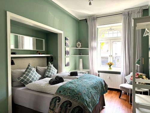 a bedroom with a bed with green walls and a window at Ferienwohnung Boppard in Boppard
