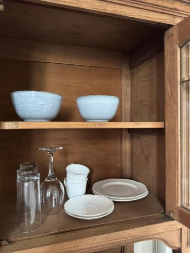 a wooden shelf with plates and bowls on it at Elfenvilla in Erkelenz