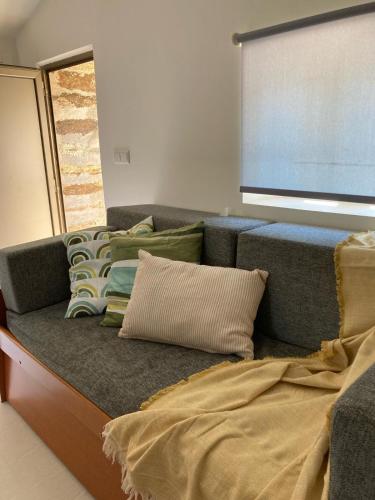 a couch with pillows on it in a room at Acushla Original House Douro in Lodões