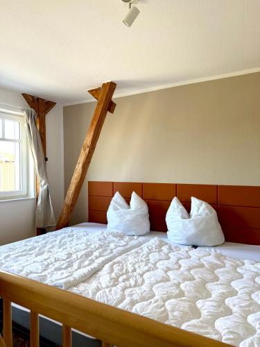 a bedroom with a large bed with white sheets and pillows at Familienbett und Sauna - Muschelbude in Wittenbeck