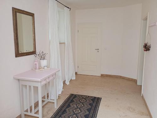 a white room with a table and a mirror at Cottage Living 2 in Leiblfing