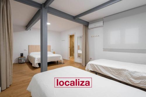 a hotel room with two beds and a room with aigiligiligiligiligil at Amplio y moderno apartamento in Almería
