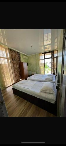 a large bedroom with two beds and a window at Rusalka in Kobuleti
