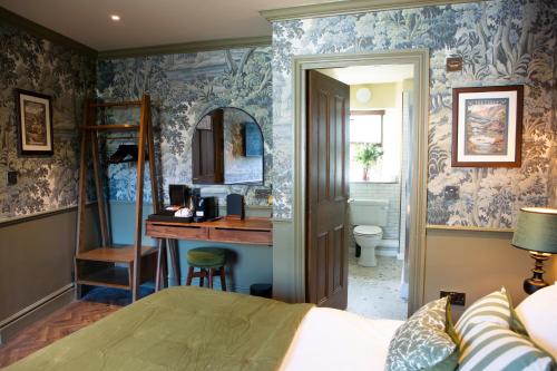 a bedroom with a bed and a desk and a bathroom at The Unicorn, Ambleside in Ambleside