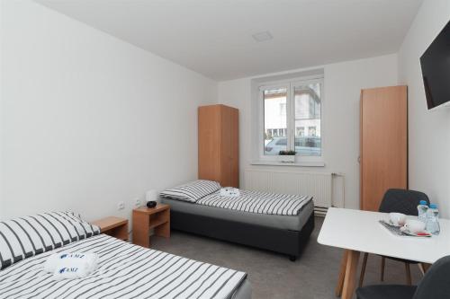 a small room with two beds and a table at Ubytování AMZ in Vrábí