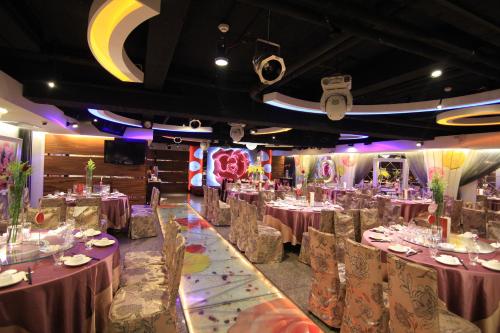 a dining room with tables and chairs and a moon at Wonderful Hall Hotel in Xinzhuang