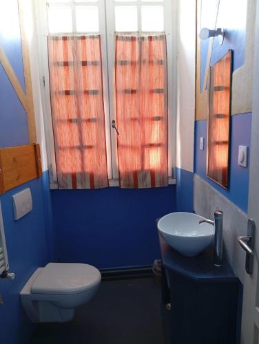 a blue bathroom with a toilet and a sink at Air de Monade in Oloron-Sainte-Marie
