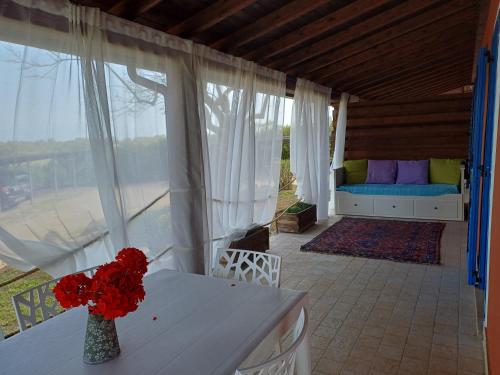 a living room with a couch and a table with flowers at Sole e Sale in Sardegna in Pula