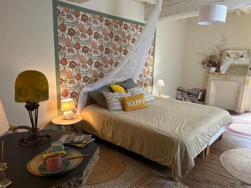 a bedroom with a bed with a mosquito net at Le presbytère in Le Crouais