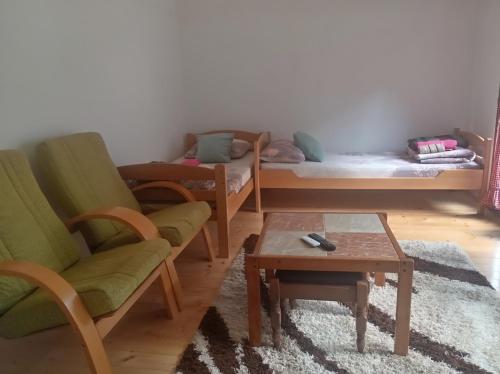 a living room with two chairs and a bed and a table at Apartman Sobek in Bajina Bašta