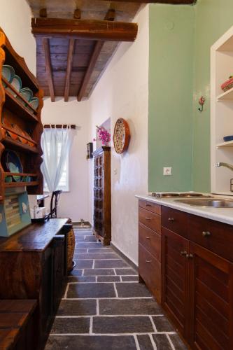 a kitchen with green walls and a stone floor at Niokratis in Áno Petálion