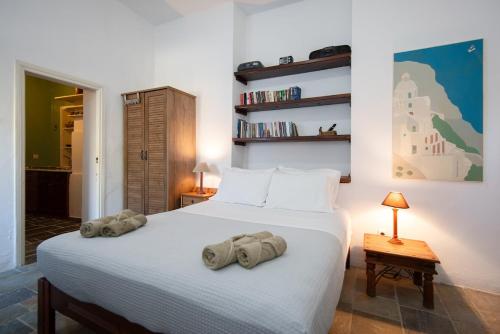 a bedroom with a white bed with towels on it at Niokratis in Áno Petálion