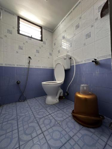 a blue and white bathroom with a toilet and a window at De Lemo 3BHK Villa Homestay in Pondicherry