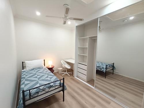 a bedroom with a bed and a desk and a mirror at Comfortable Queen Room - Merrylands - NM4 in Merrylands