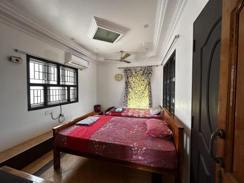 a bedroom with a red bed in a room at De Lemo 3BHK Villa Homestay in Pondicherry