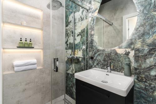 a bathroom with a sink and a shower with a mirror at Oliwa Am Calsberg 5a in Gdańsk