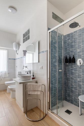 a white bathroom with a sink and a shower at Blue Terrace Guest House in Alghero