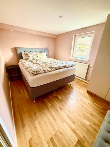 a bedroom with a bed and a wooden floor at Charmigt in Gränna