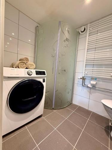 a washing machine in a bathroom with a shower at Charmigt in Gränna