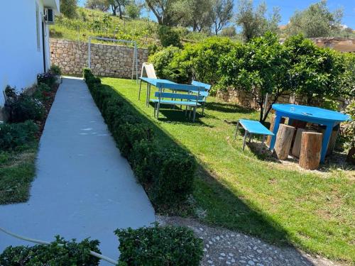 two blue benches and a table in a yard at Vila 3 palmat in Ksamil