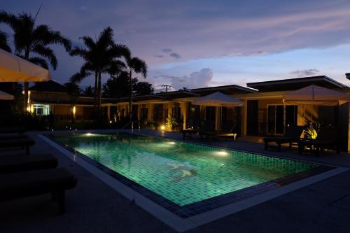 a swimming pool in front of a house at night at The Oasis Khaolak Resort - SHA Plus in Khao Lak
