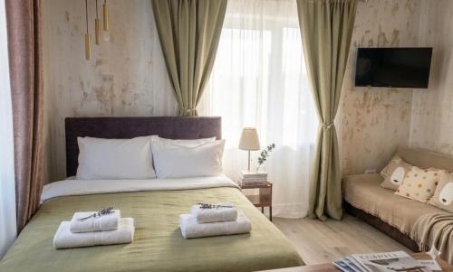 a bedroom with a large bed with towels on it at Casa Rahova - centru civic in Brăila