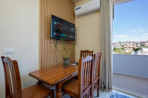 a dining room with a table and chairs and a window at Sea Vibe Apartment in Polisi i Vogël