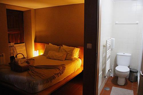 a small bedroom with a bed and a toilet at Casa da Comareira in Góis