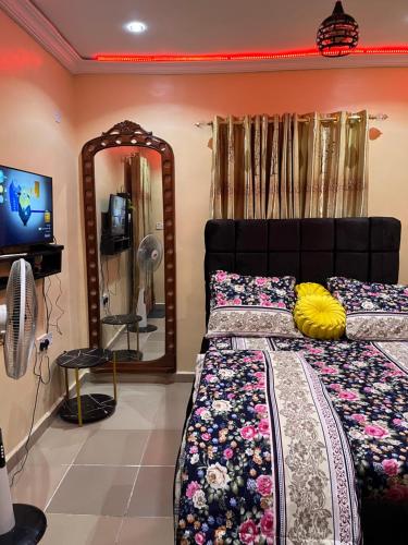a bedroom with a bed and a mirror at RYN Apartment Ayobo-Ishefun, Lagos Flat1 in Itele