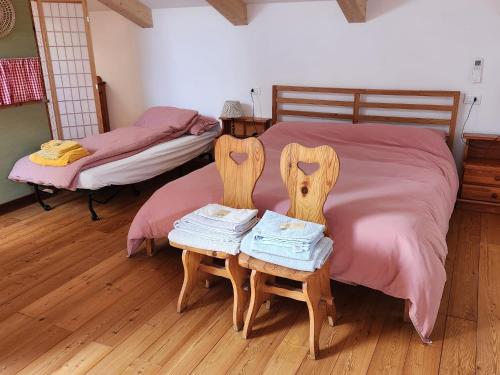 a bedroom with a bed and two chairs with towels at Openspace in legno La Casa sull'Albero in Osimo
