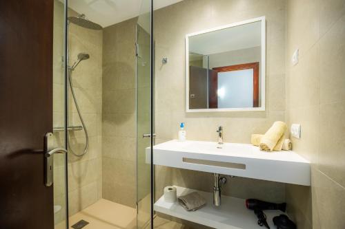 a bathroom with a sink and a glass shower at Cala Figuera Apartment 3b in Cala Figuera