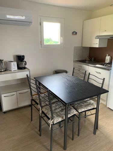a black table and chairs in a kitchen at Gîte du Phare in Lanquais