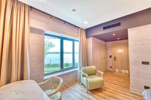 a room with a bed and a chair and a window at Duman Boutique Hotel in Mamaia