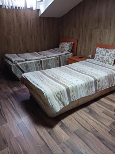 two beds in a room with wooden floors at Hostel Center Plovdiv in Plovdiv
