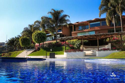 un complejo con piscina frente a un edificio en El Santuario Resort & Spa en Valle de Bravo