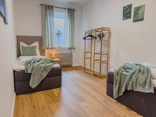 a living room with two beds and a book shelf at Homelystays Stilvolles Apartment an der Kirche in Lemförde
