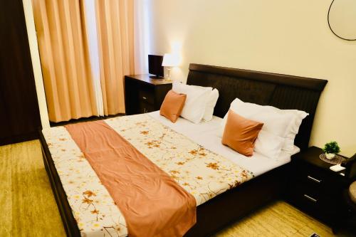 a bedroom with a bed with orange and white pillows at The Moksh in Haridwār
