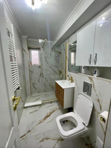 a white bathroom with a toilet and a sink at Luxbab in Drobeta-Turnu Severin
