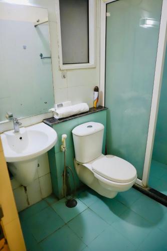 a bathroom with a white toilet and a sink at The Moksh in Haridwār