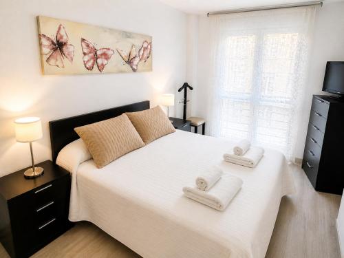 a bedroom with a bed with two towels on it at Apartamento TIERRA in Viveiro