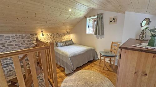 a bedroom with a bed and a staircase in a room at Le clédier de cherveix in Solignac